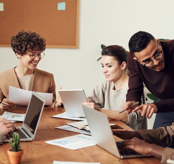 A diverse group of professionals engaged in a collaborative office meeting, sharing ideas and discussing projects.